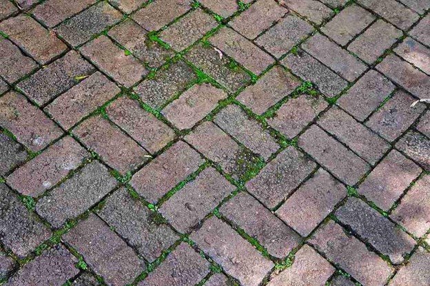 Uneven patio surface with shifting pavers and gaps before concrete patio replacement in Eastlake, OH